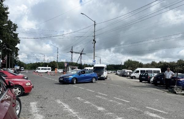 Road area with cars parked in different positions and a man standing next to one. 