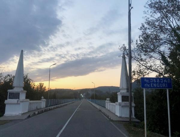 Bridge in sunset period with lights showing on the other side.