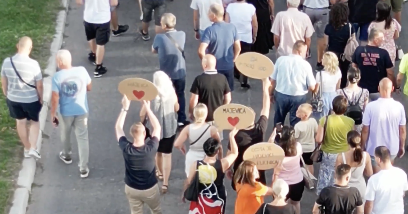 Activists in the protest against mining in Majevica mountain walking down the street and holding signs, including one that says <3 Majevica