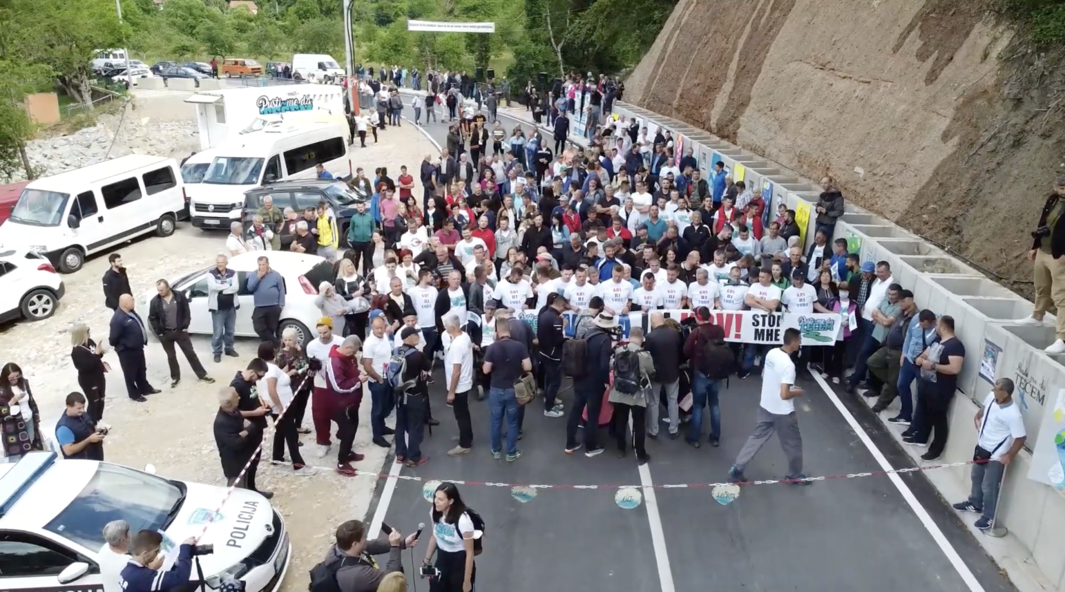 Protest against micro hydropower plants construction in BiH showing a group of activists holding banners at a plant construction site.