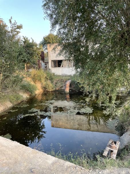 Water accummulation with a building in the background.